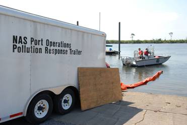 NAVAL AIR STATION PENSACOLA, Fla. - Naval Air Station Pensacola's Pollution Response unit deploys an oil containment boom at Sherman Cove to protect environmentally sensitive grass beds from the Deepwater Horizon oil spill, May 4, 2010. U.S. Navy photo by Patrick Nichols. 